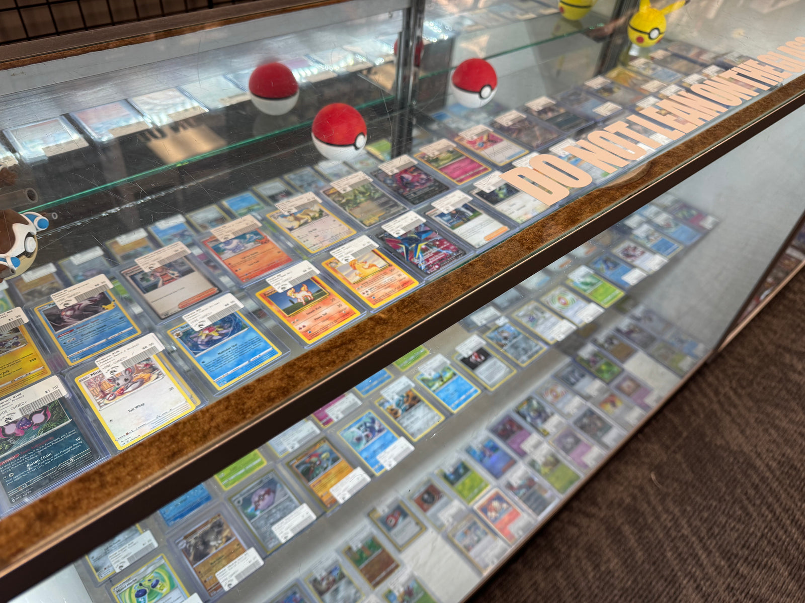 pokemon card singles displayed in glass case at 8-Bit Legends card shop in Jonesboro Arkansas