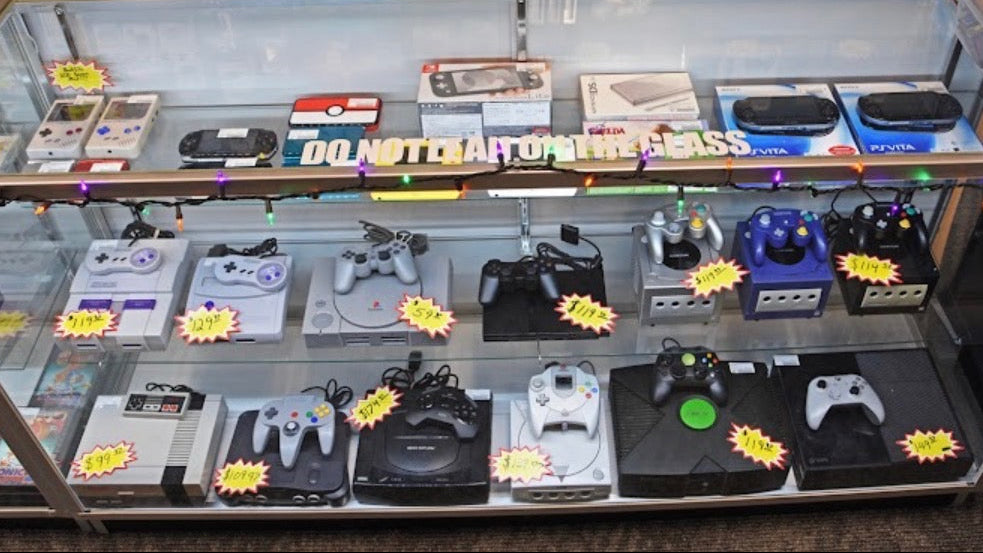 retro video game consoles including nintendo and playstation in display case at 8-Bit Legends retro video game store in Jonesboro Arkansas